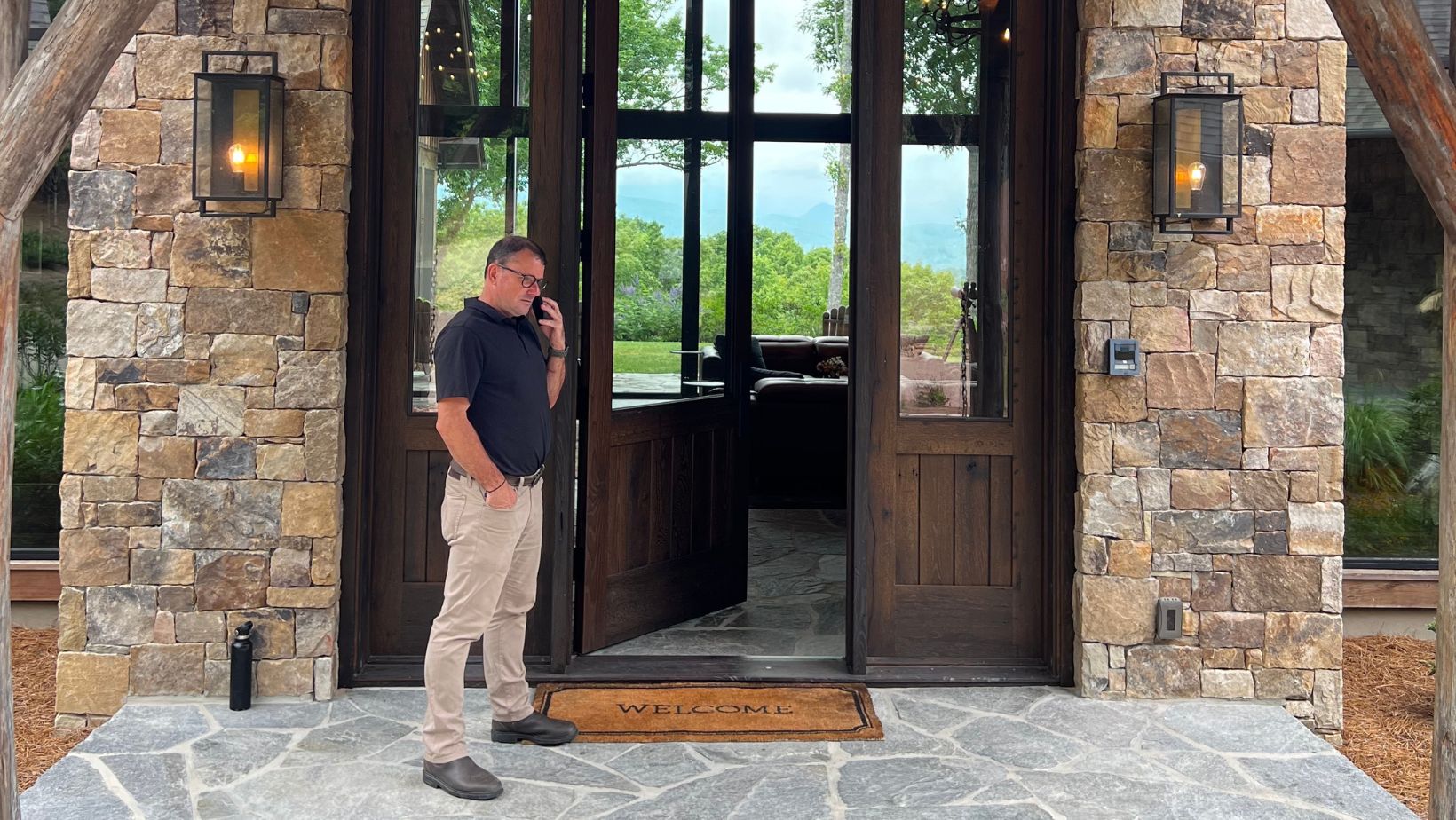 Billy Harris on the phone outside of a luxury home in Brevard NC